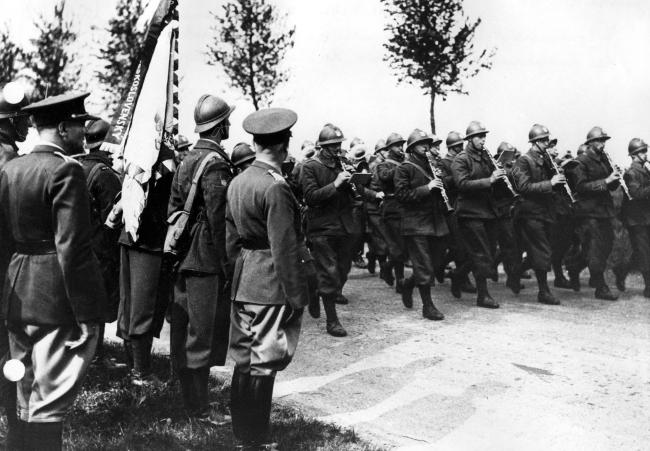 Les volontaires tchèques et polonais défilent devant les drapeaux qui viennent de leur être remis, Artois, 1940 (Fonds du comité d’histoire de la Seconde Guerre mondiale, SHD, DE 2007 ZC 18/1 5934).